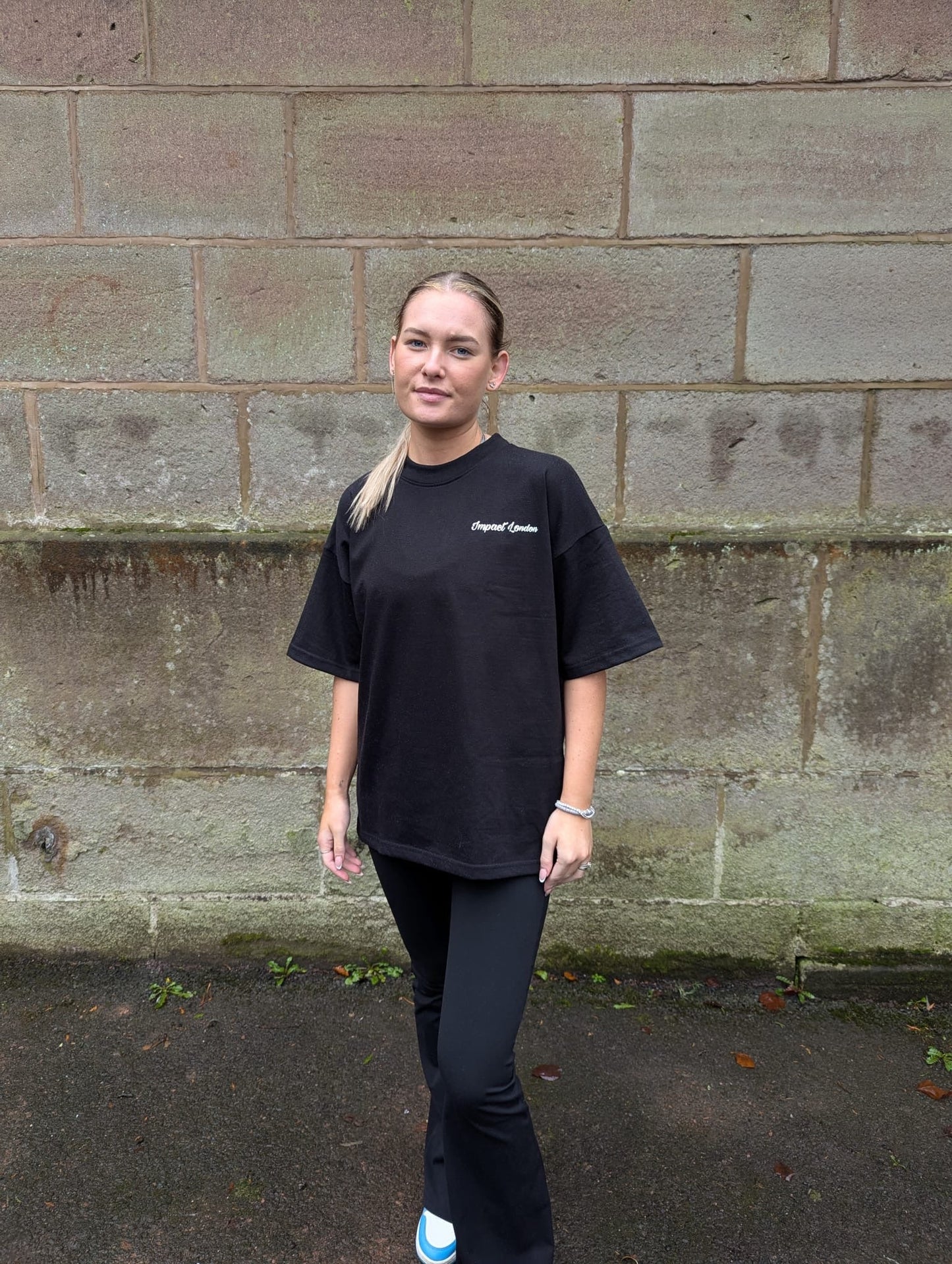 Close up of female model wearing Impact London black t-shirt