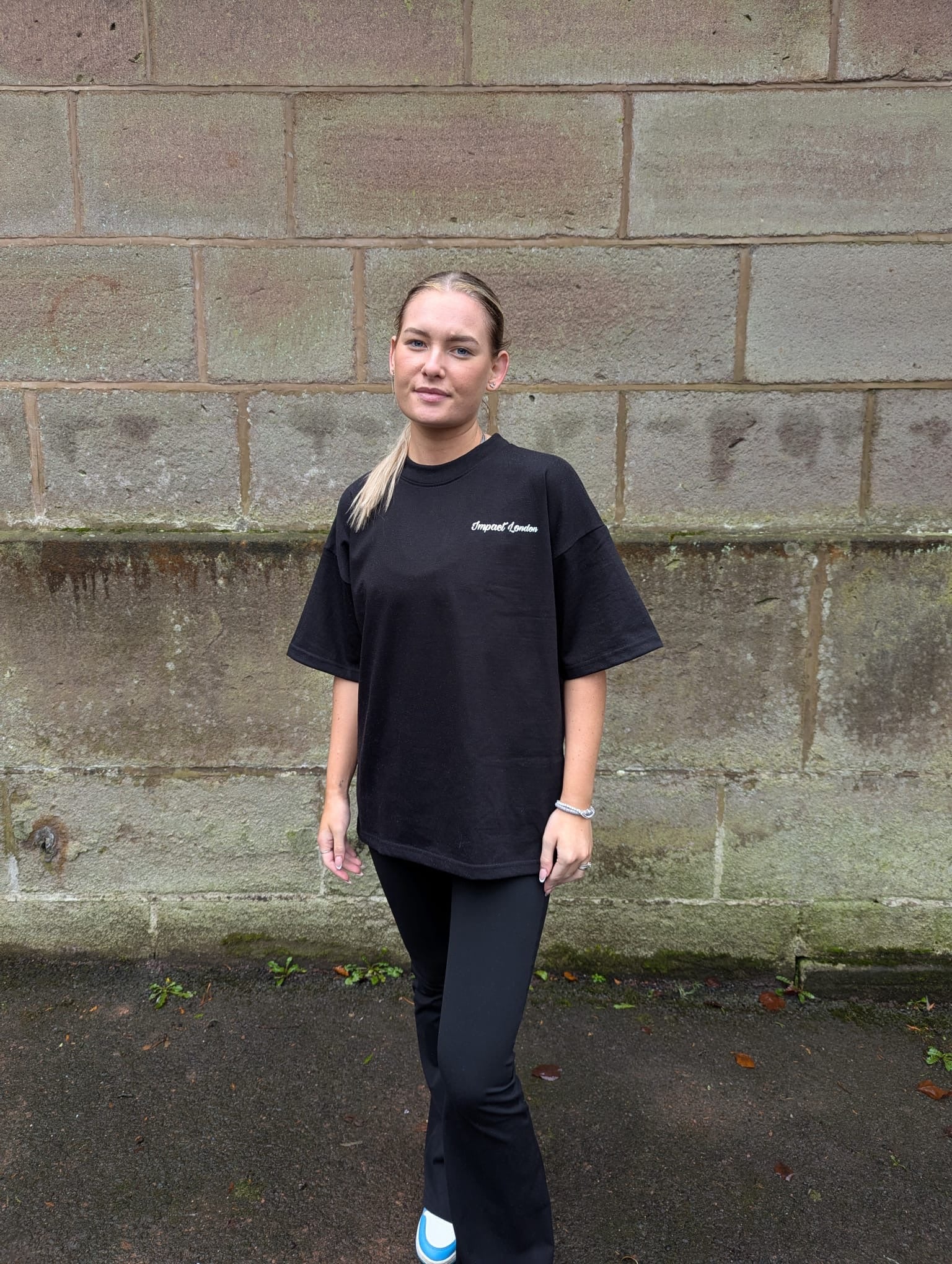 Close up of female model wearing Impact London black t-shirt
