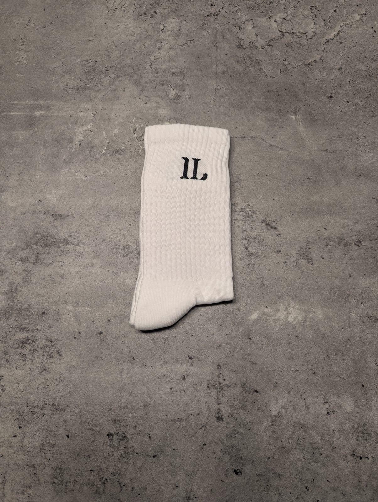 Folded white ankle socks with black IL logo