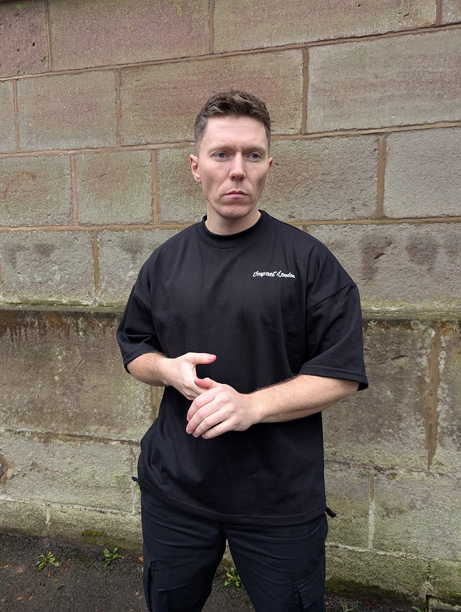 Front of Unisex Oversized Black T-Shirt showing white printed logo