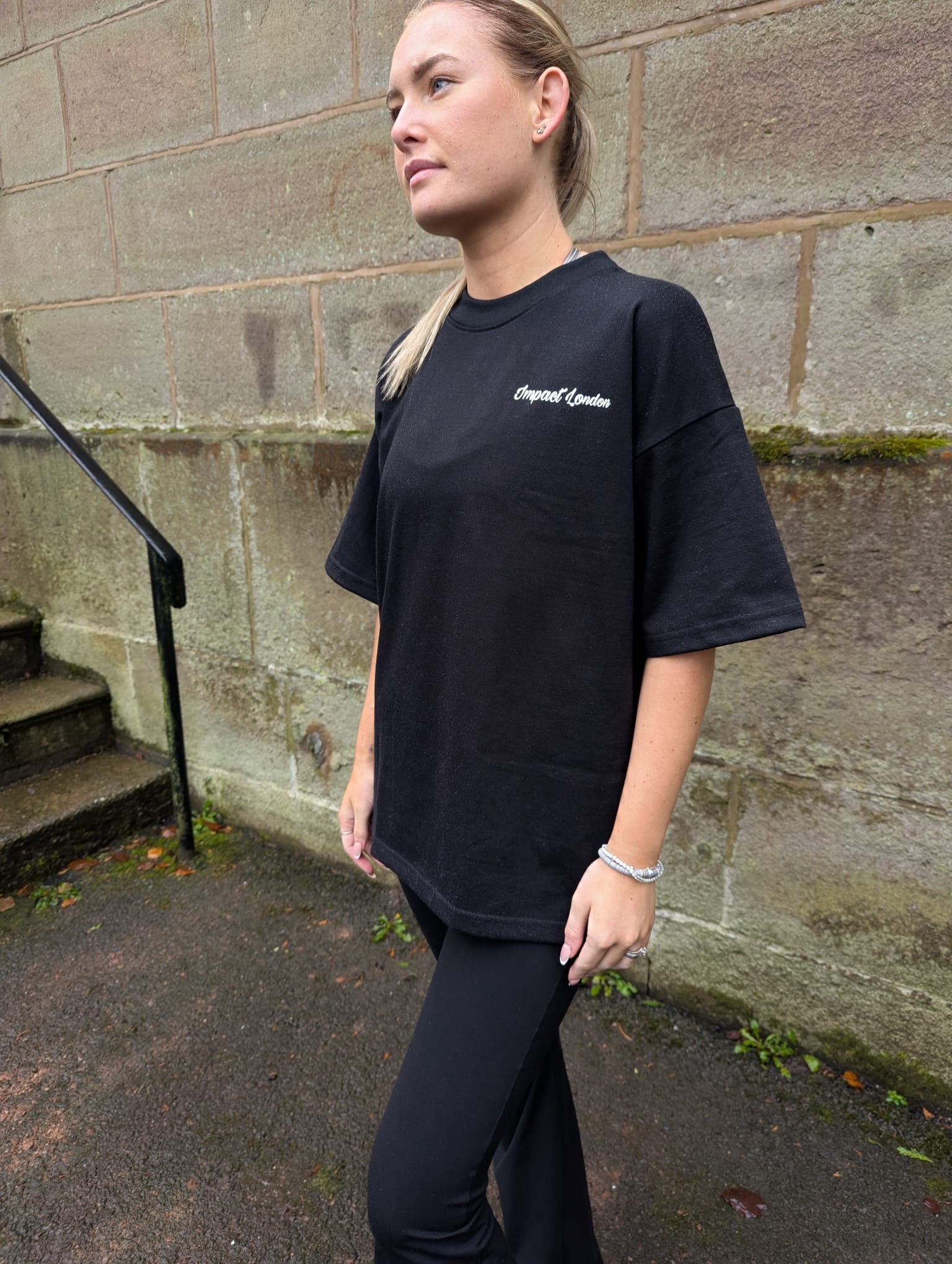 Close up on white Impact London printed logo to the left of the chest