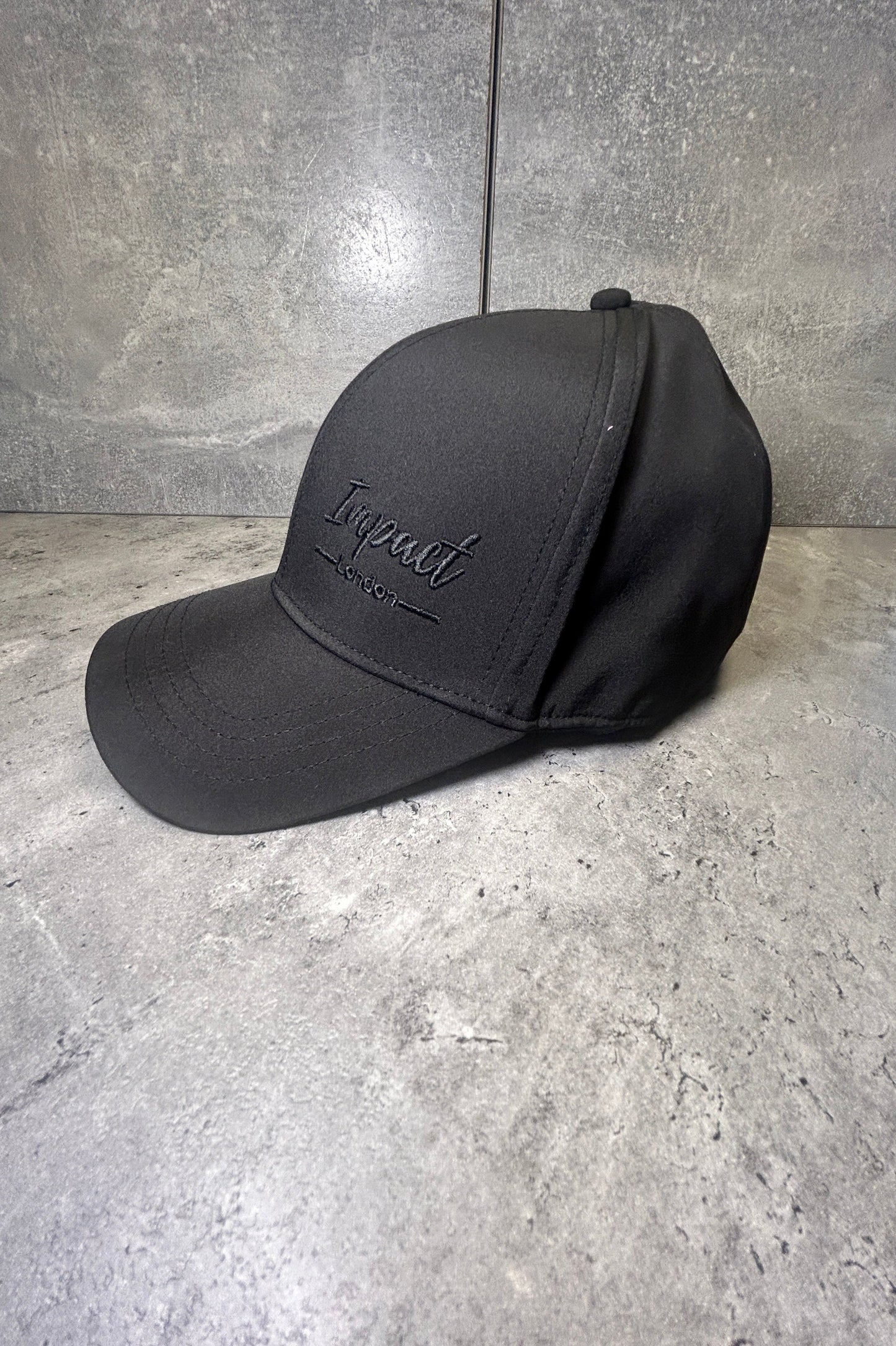 Unisex black soft shell cap with black stitched logo