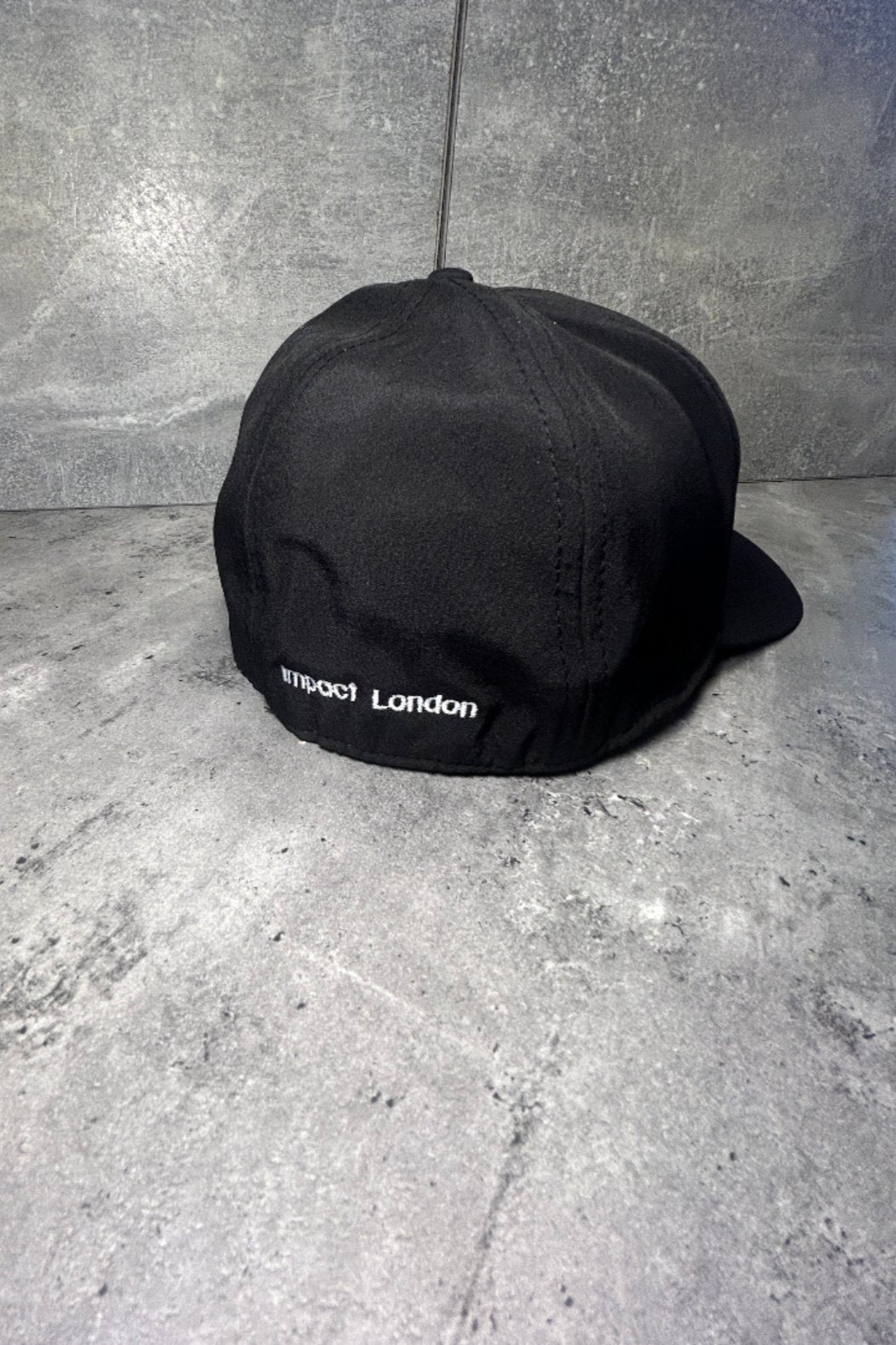 The back of black soft shell cap with small white logo on the back